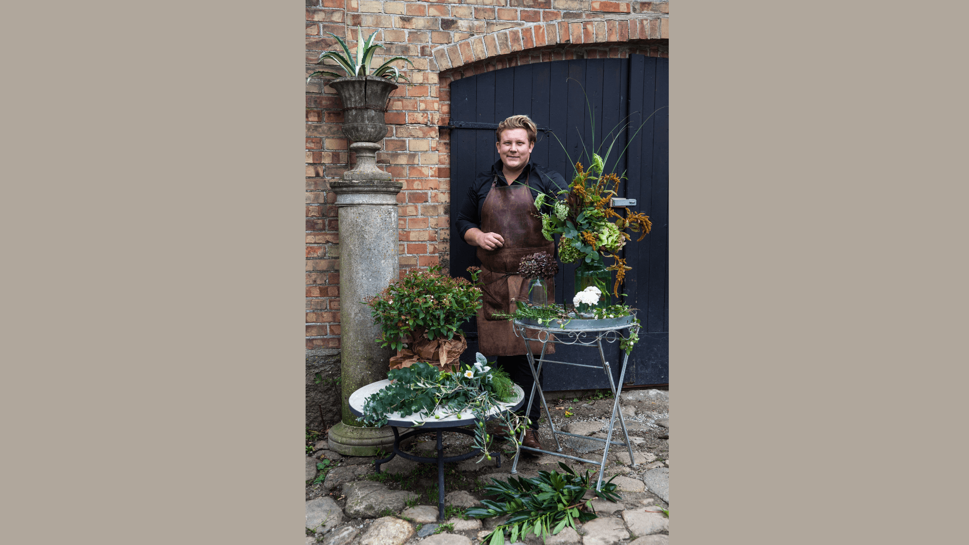 Karl Fredrik vid ett par bord fyllda med växter