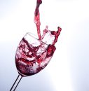 Ett vinglas med rött vin som skvätter